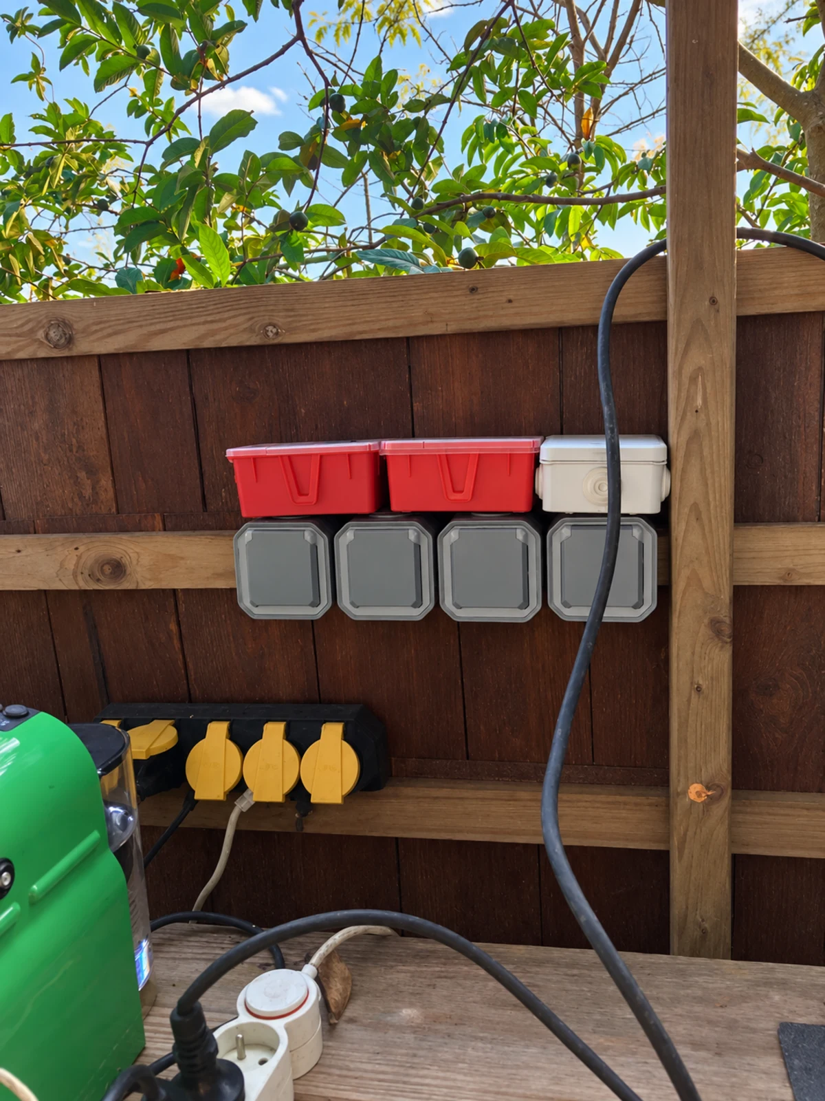 The outdoor electrical panel and weatherproof sockets mounted on the timber