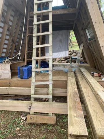 Ladder and timber in front of the cabin during the build